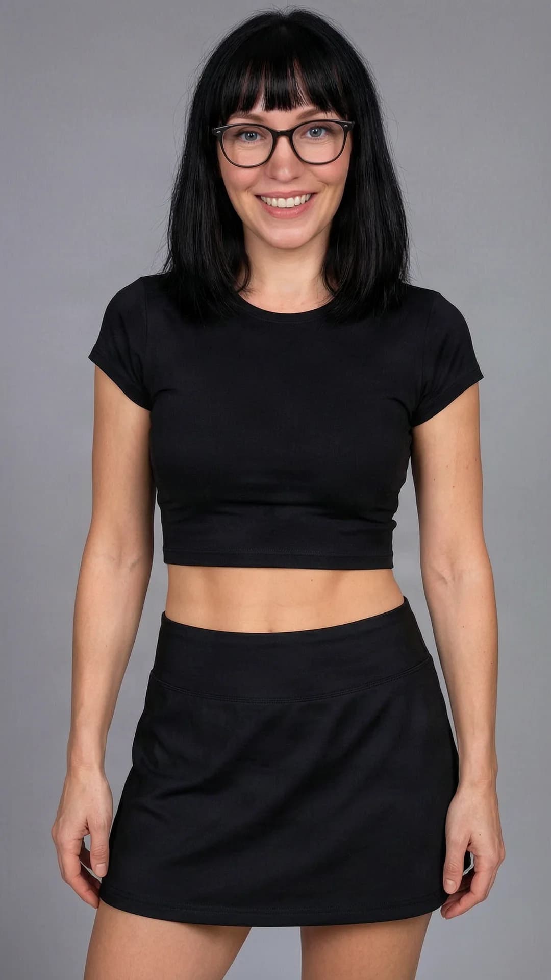 A 36-year-old Caucasian woman with black hair in bangs, blue eyes, skinny body type and wearing glasses, dressed in a short black tennis skirt and a tight crop top shirt that reveals her midriff, standing in a confident upright pose with shoulders slightly angled toward the viewer, medium close-up front-facing portrait at eye level, direct intense eye contact with the viewer and a bright genuine smile, soft natural lighting highlighting her facial features and smooth skin texture, realistic style, cheerful mood, Flawless anatomy, no extra digits, no extra limbs, realistic skin texture, high-detail.